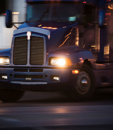 Supply Chain Scene, image of the front of an 18 wheeler truck at night 