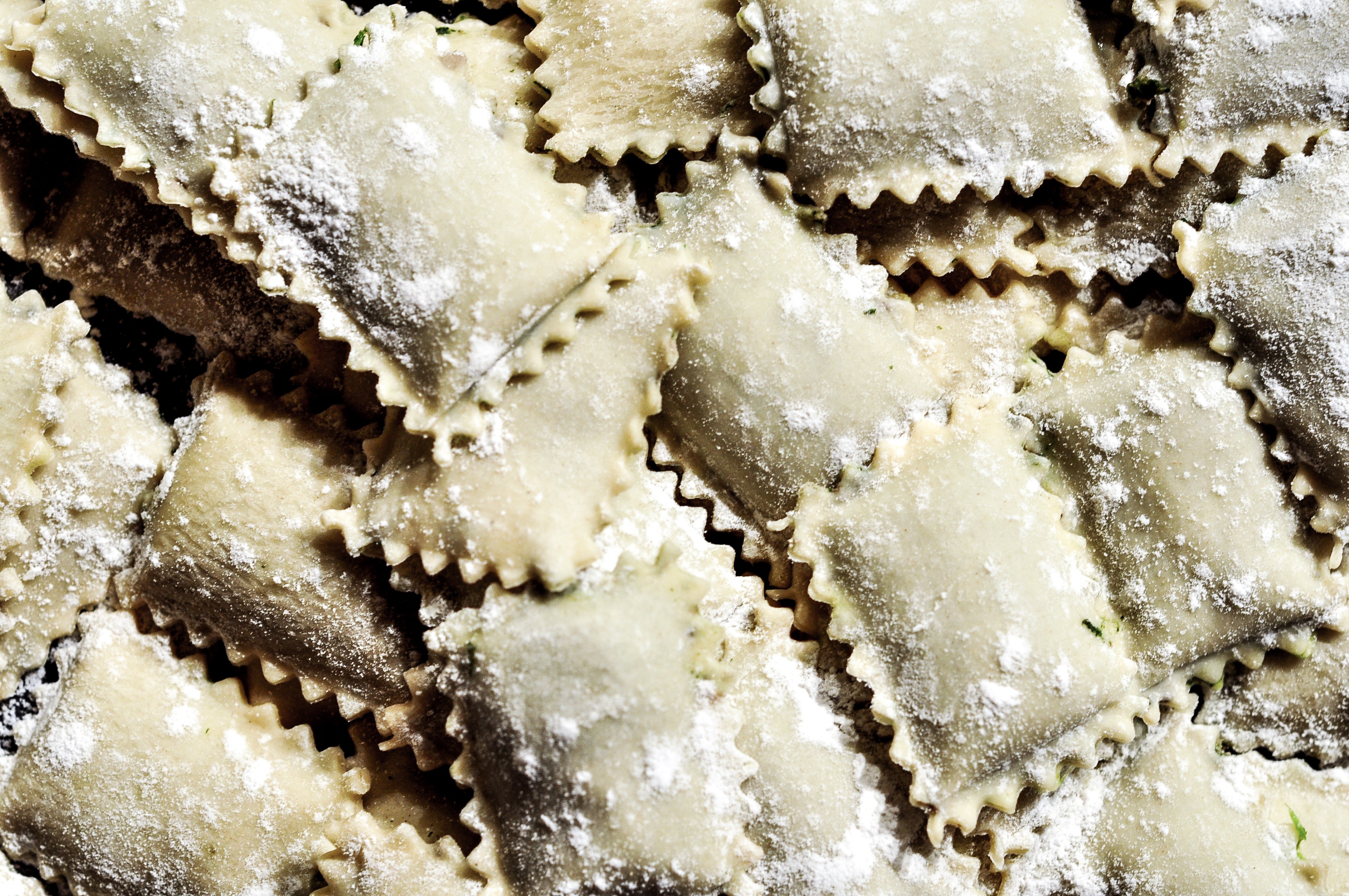 Uncooked ravioli dusted with flour.