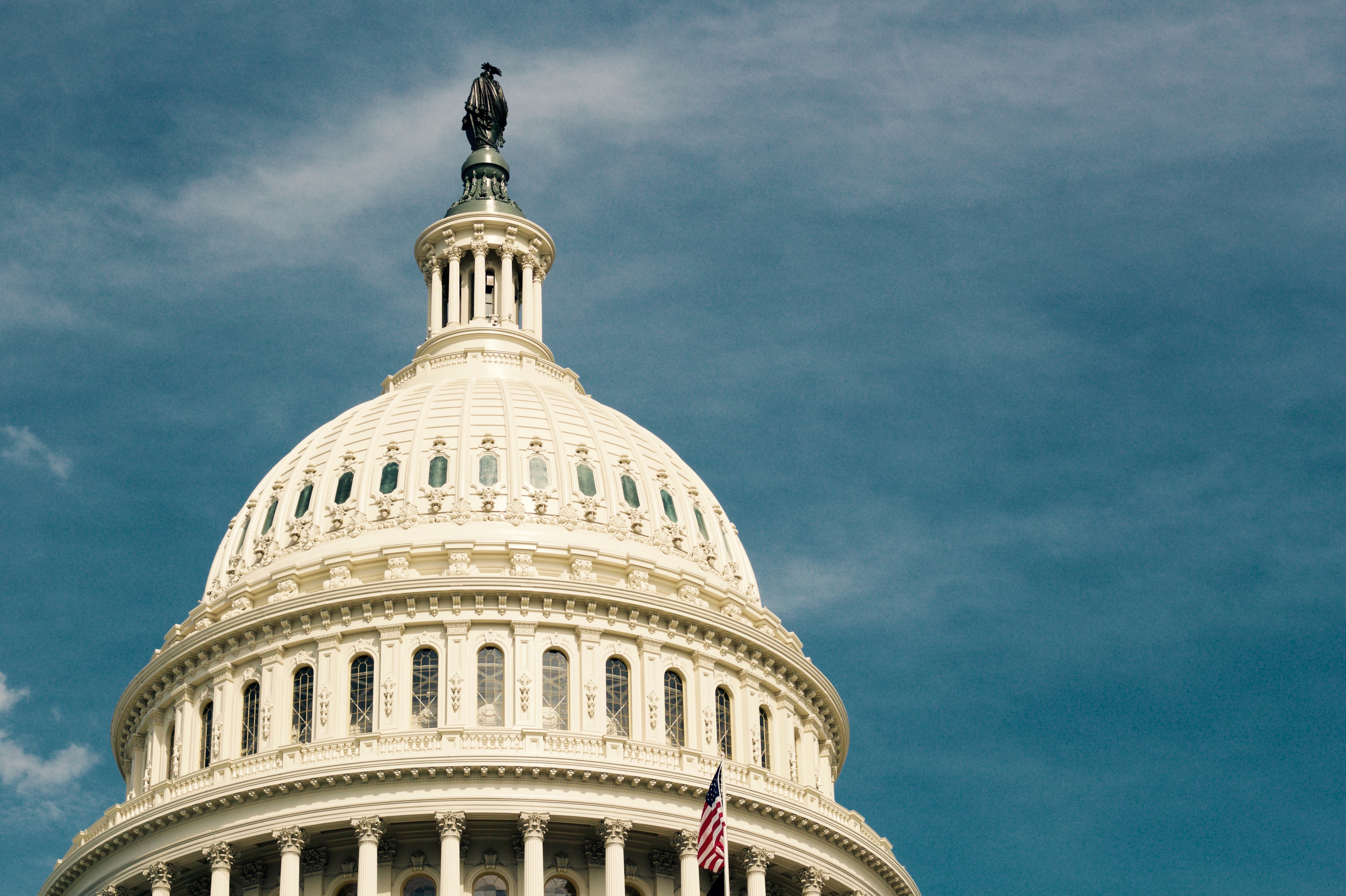 U.S. Capitol building dome with blue sky behind.