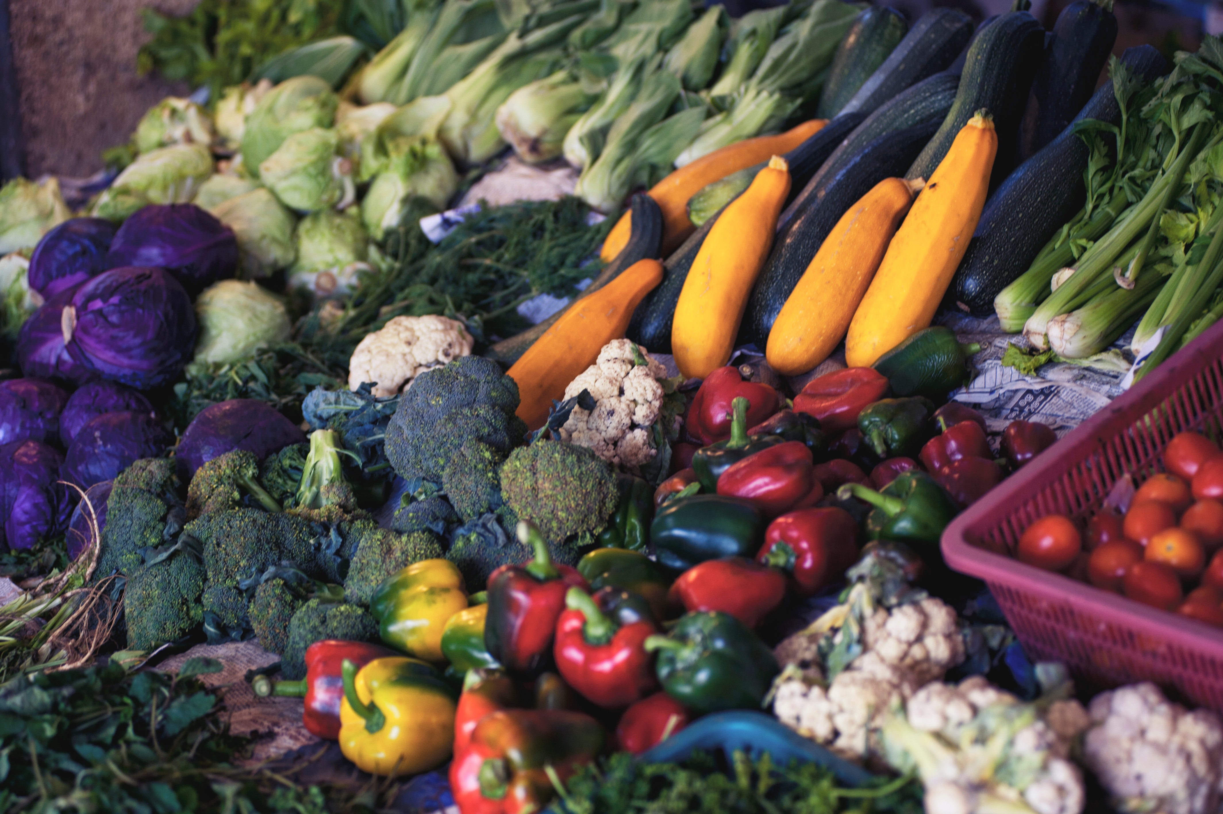 Various vegetables of many colors in a vegetable stand.