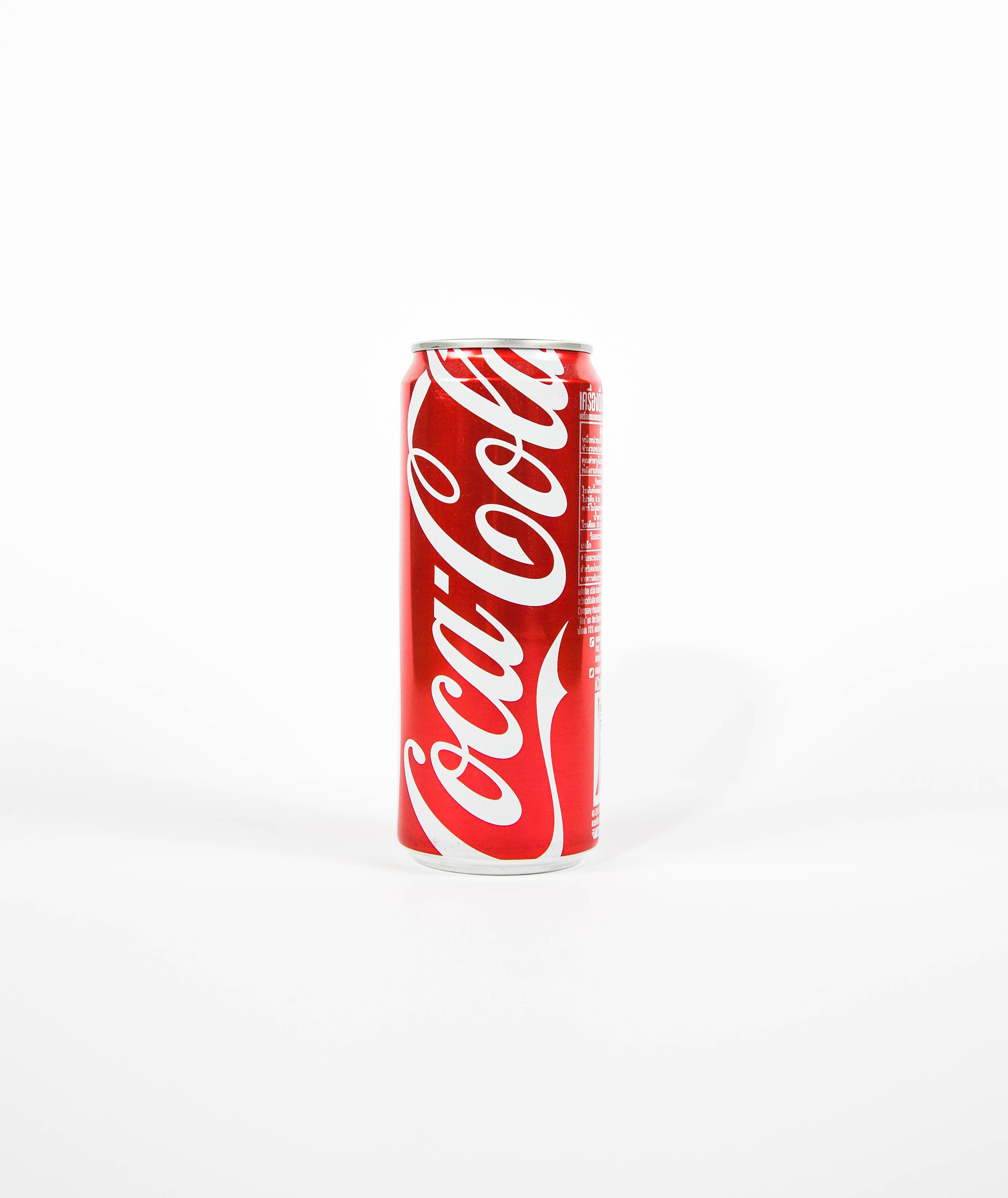 Narrow can of Coca-Cola against white background