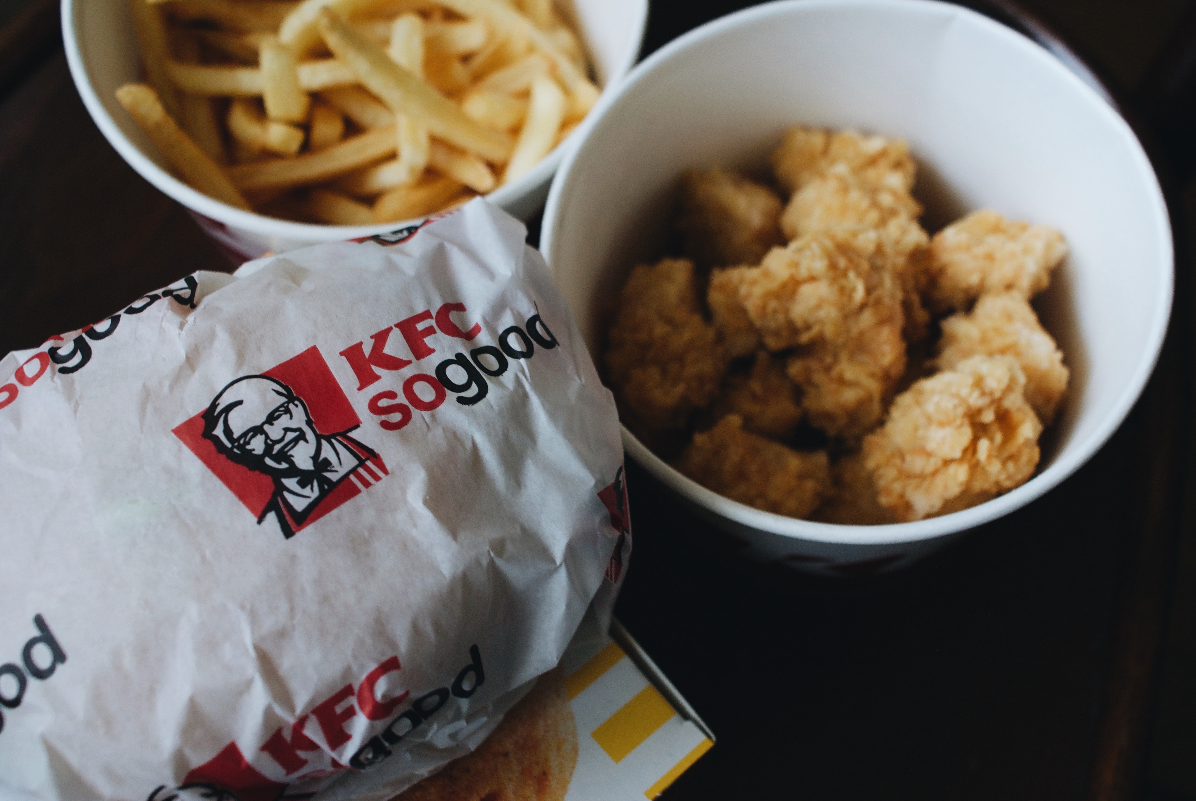 Image of KFC wrapper and bucket of fried chicken and fries.