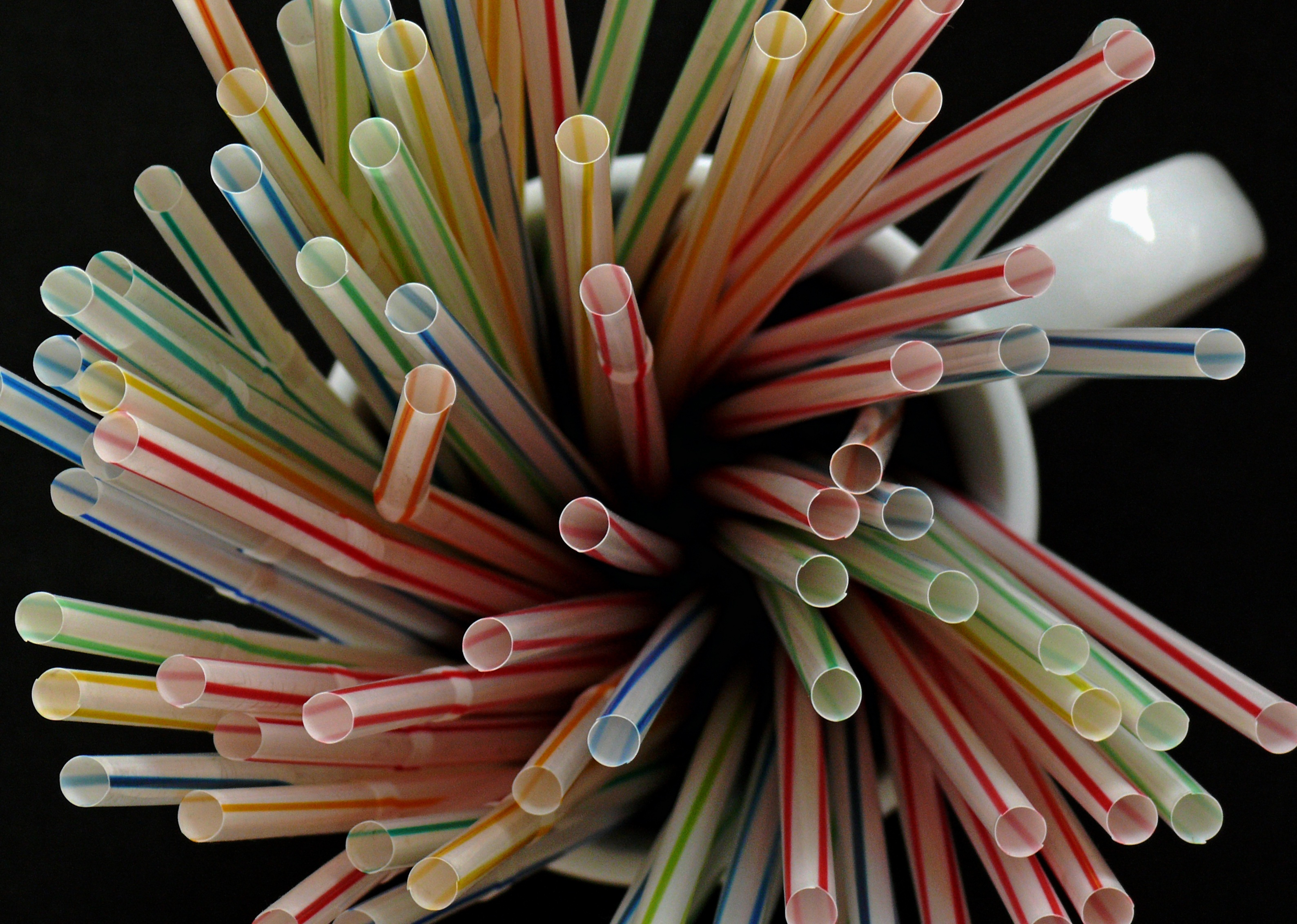 Multi-colored straws in white mug