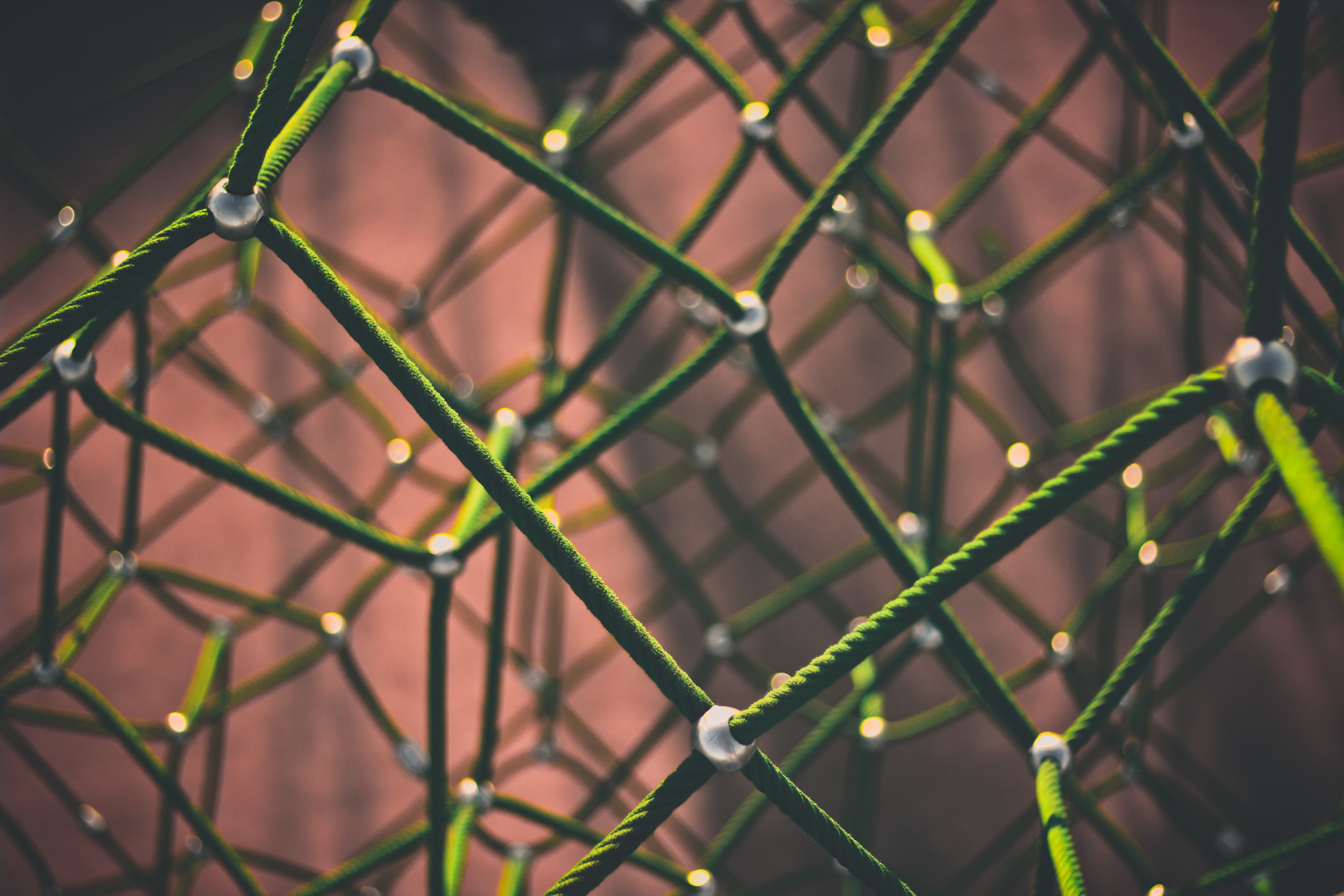 Image of connecting metal pieces in a gridlike manner (peach colored background)