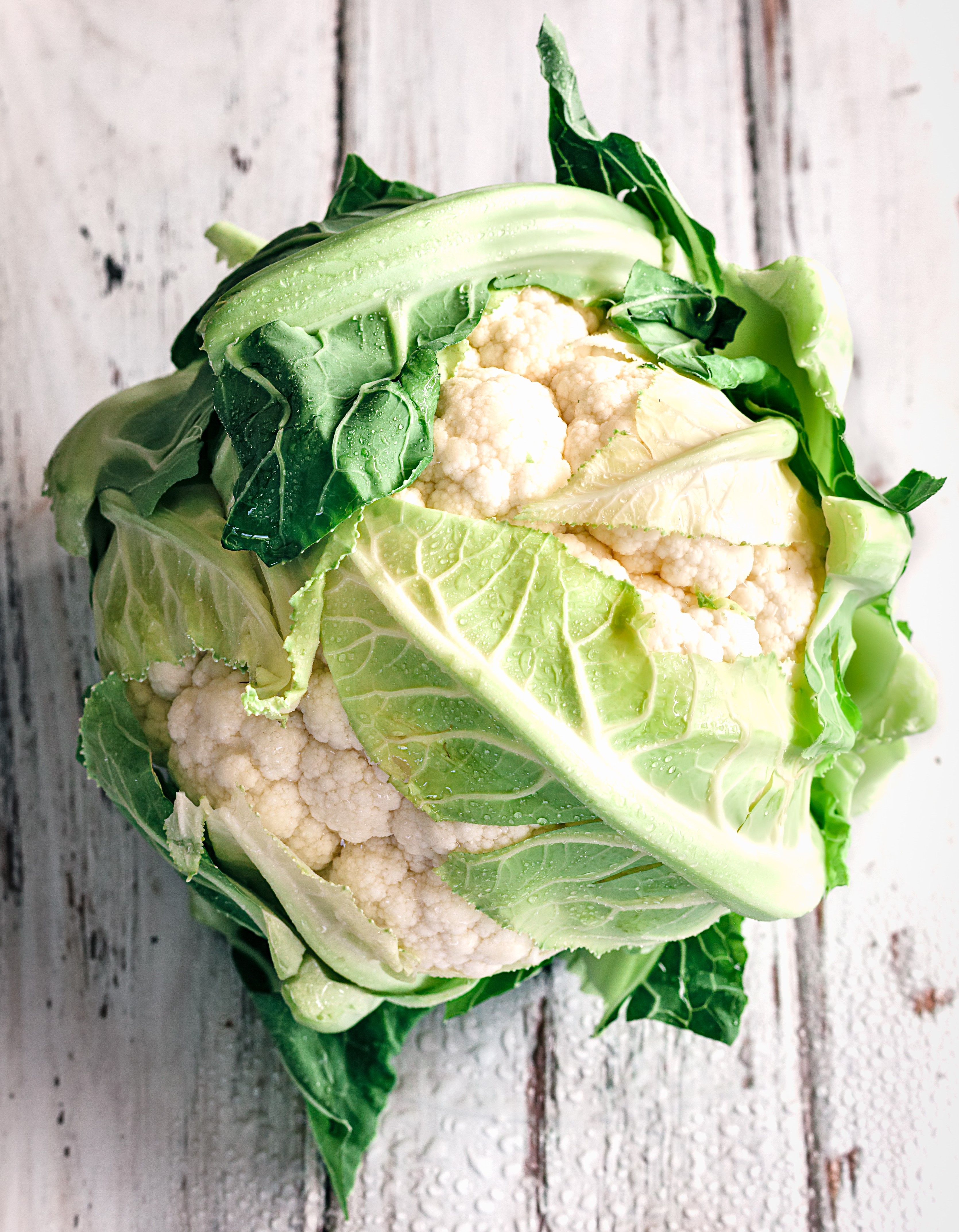 Whole cauliflower on white washed wood