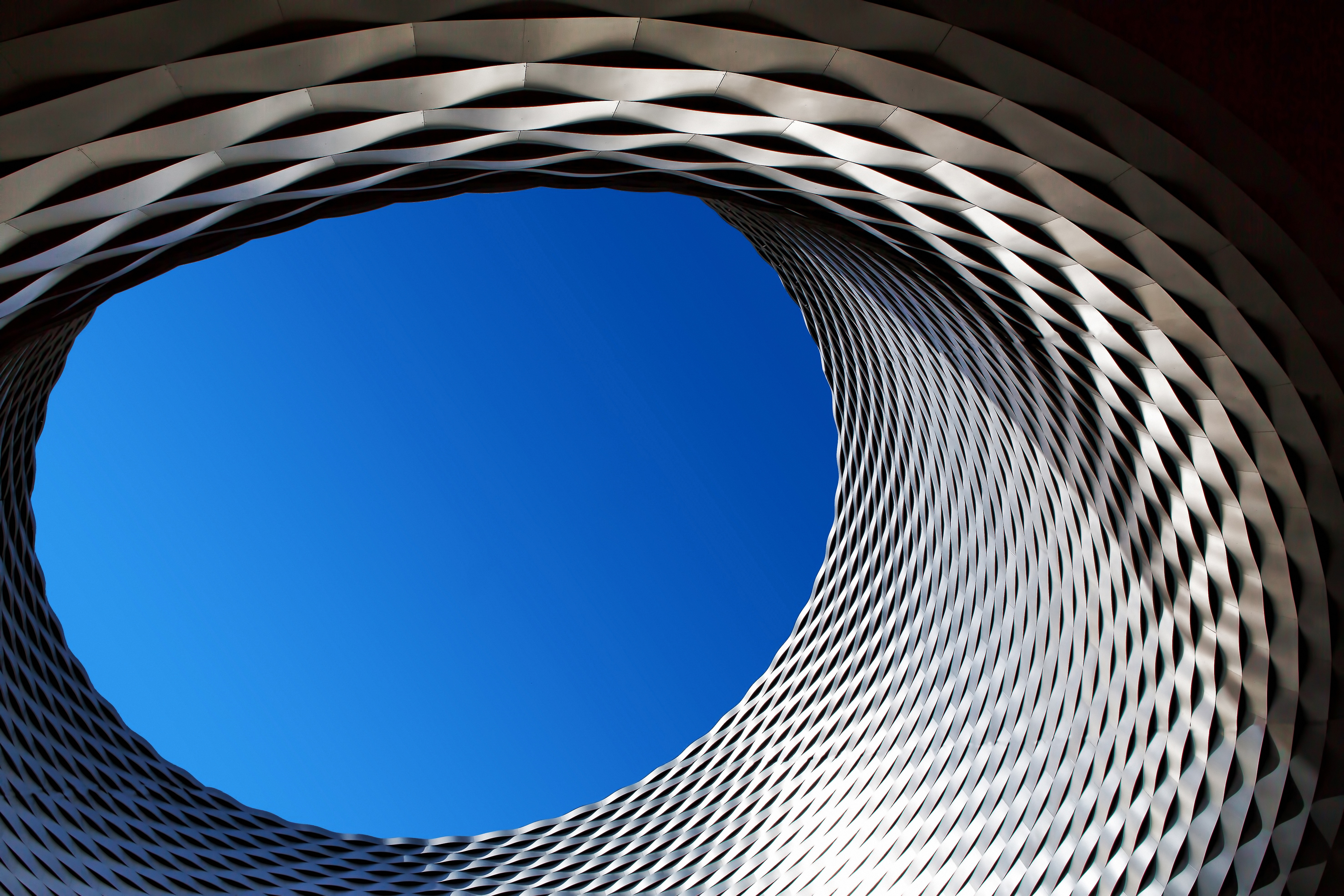 Convention Center building in Messeplatz (looking up through a circular building with blue sky overhead)