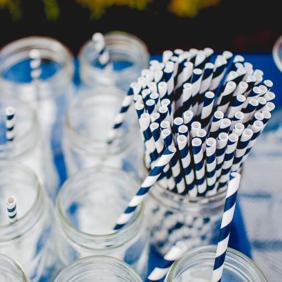 Blue and white paper straws in clear glass jars.