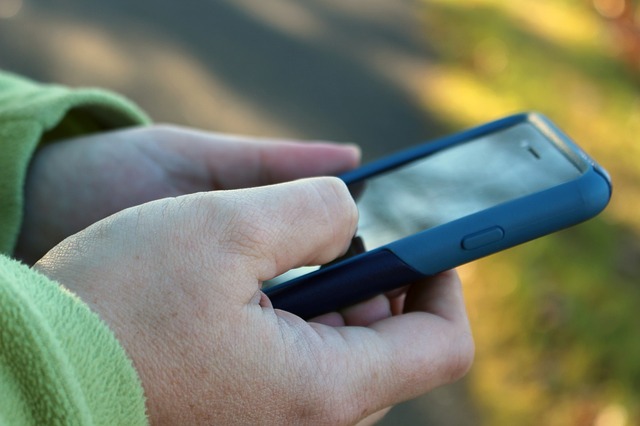 Hands of person holding a blue cell phone