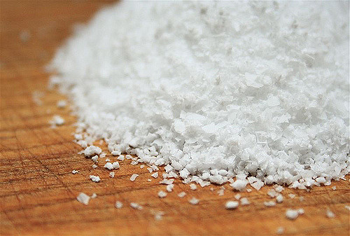 Kosher salt piled on wooden cutting board