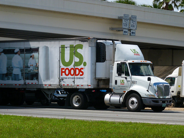 US Foods truck passing underneath bridge.