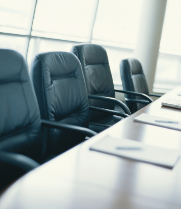 Supply Chain Scene, image of empty chairs at a board table 