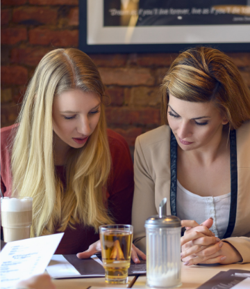 Supply Chain Scene, image of women in restaurant looking at menu 