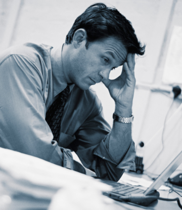 Supply Chain Scene, image of a stressed out person looking at a laptop