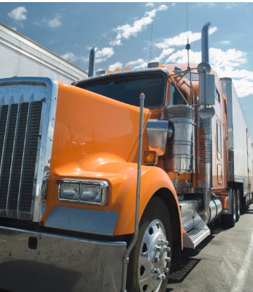 closeup image of the front exterior of an organge cab 18-wheeler 