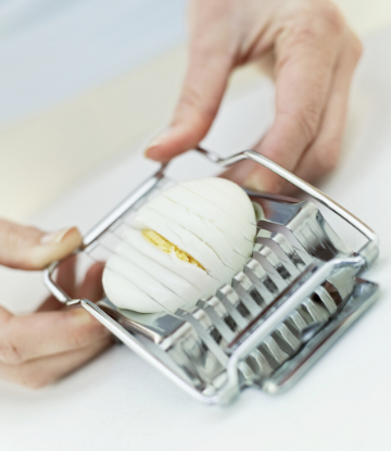 SCS, image of a hard boiled egg in a metal slicer 