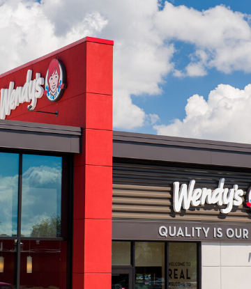 Image of a Wendy's storefront against a blue sky with white clouds