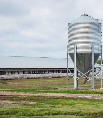 SCS, image of a farm exterior with feeder, containment shed 