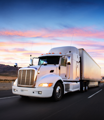 SCS, image of an 18-wheeler reefer at sunset on the highway 