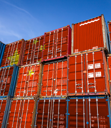 SCS, image of a 3-tiered stack of red shipping containers 