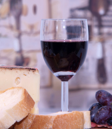 Image of a glass of red wine with cheese and grapes 