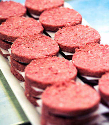 Platter stacked with raw hamburger patties 