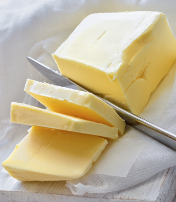 a stick of butter being sliced 